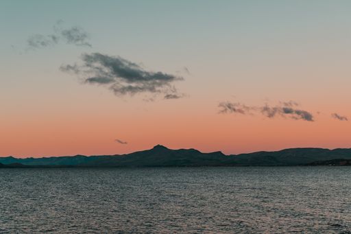 A mesmerizing shot of the pink orange sunset sky over the mountains and the sea