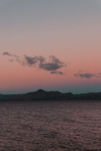 A mesmerizing shot of the pink orange sunset sky over the mountains and the sea