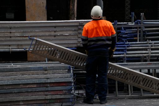 A construction worker holding a metal pipe