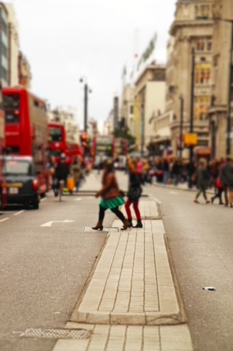 A busy Oxford Street in London with crowds of people and iconic red double-decker buses