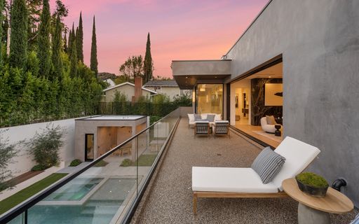 Outdoor living area with patio furniture and poolside lounge chairs for relaxation and enjoyment