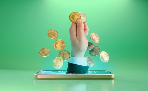 Hand holding smartphone with coins pouring out