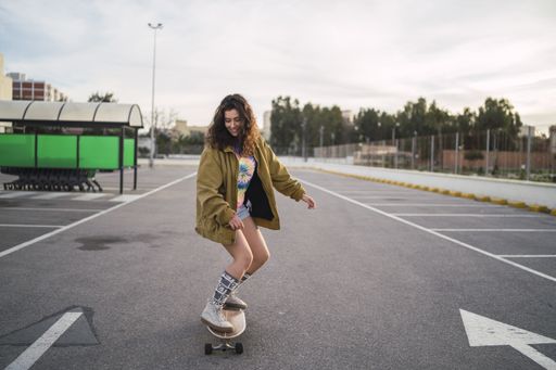 A girl riding a skateboard in the park during daytime