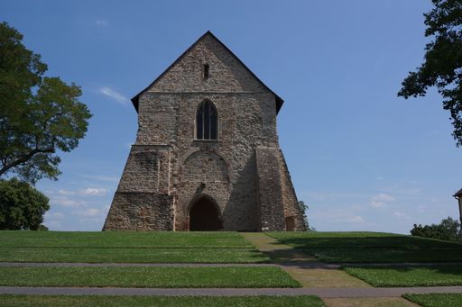 An aged brick church gracefully rests atop a lush green hill