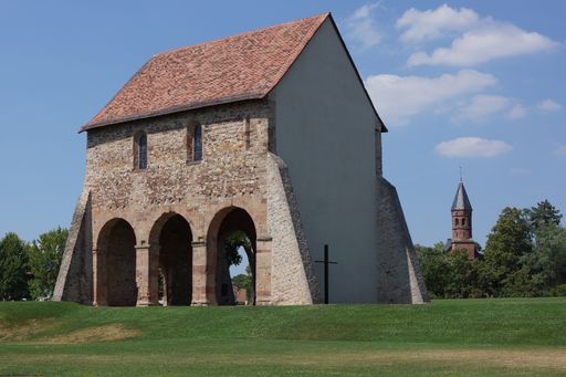 Church fragments of the Lorsch Abbey, Hesse, Germany, on a blue summer day. UNESCO World Heritage Site. Protestant church in the background.