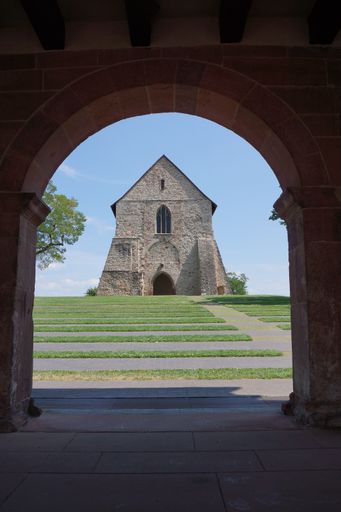 Lorsch Abbey, Hesse, Germany. UNESCO World Heritage Site. Church ruins seen through the arch of the gatehouse on a sunny summer day.