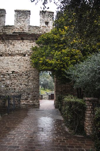 A vertical shot of a beautiful Rocca Scaligera Castle in Sirmione, Italy with a white sky in the background
