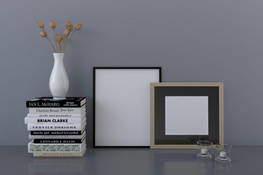 A closeup shot of frames with a vase and books on the shelf