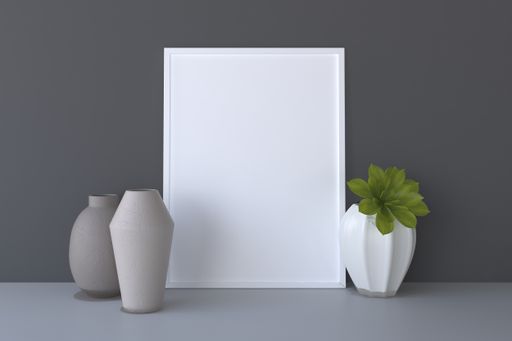 A closeup shot of a white frame with vases on a gray wall background