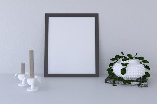 A closeup shot of a black frame with decorative items on a gray wall background