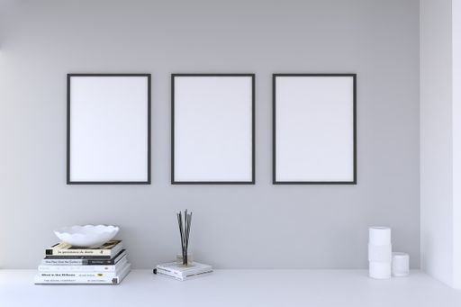 A closeup shot of frames with books and candles on the shelf