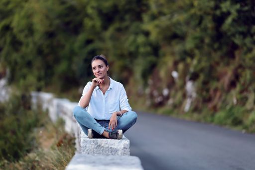 A young Caucasian female sitting by the road and enjoying the nature of Montenegro