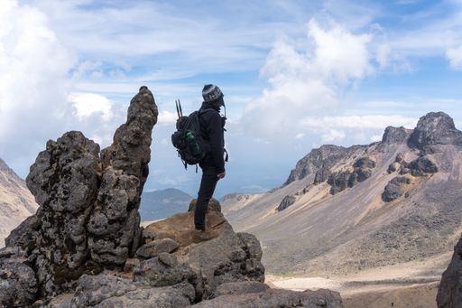 A back view of a hiker with a backpack on top of the Iztaccihuatl volcano