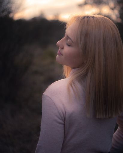 A side-view portrait of a beautiful Hispanic blonde girl at sunset