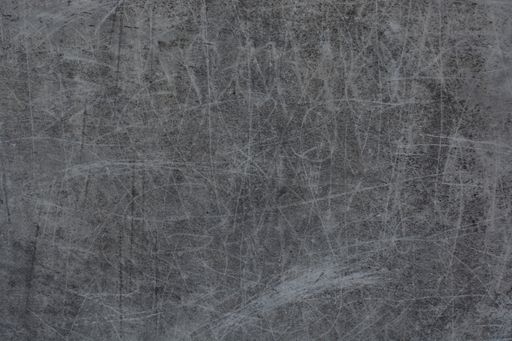 A weathered, grungy gray wall background with scratch marks