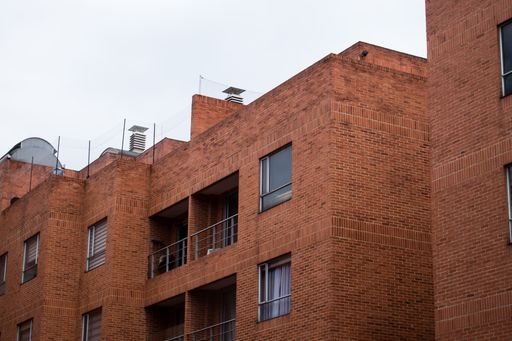A low angle shot of a brick building with balconies