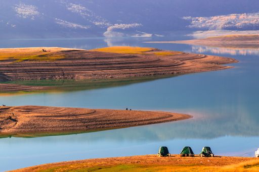 A mesmerizing view of three covered boats in Lake Tuzkol, Kazakhstan