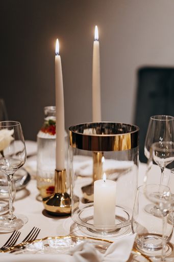 A dinner table adorned with lit candles and elegant glassware