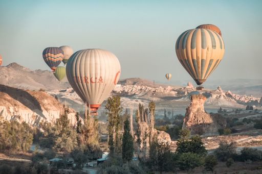 A serene view of the hot air balloons over the “fairy chimney” mountains in magical Cappadocia