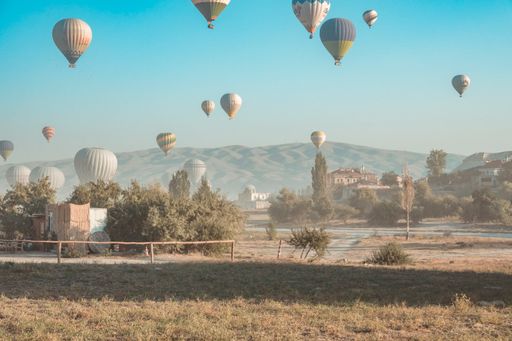 A breathtaking view of hot air balloons flying high above Cappadocia at dawn in Turkey