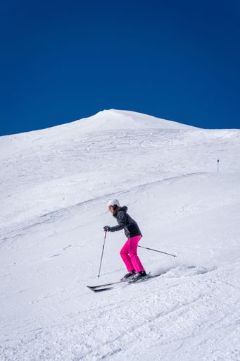 A skier gracefully glides on the snowy slopes