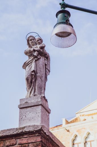 A vertical low angle shot of a statue in Venice