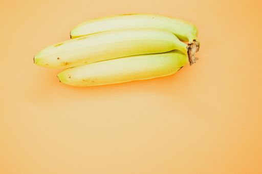 A high angle shot of ripe bananas isolated on light orange background