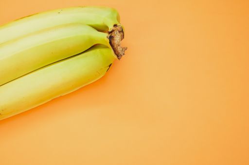 A high angle shot of ripe bananas isolated on light orange background