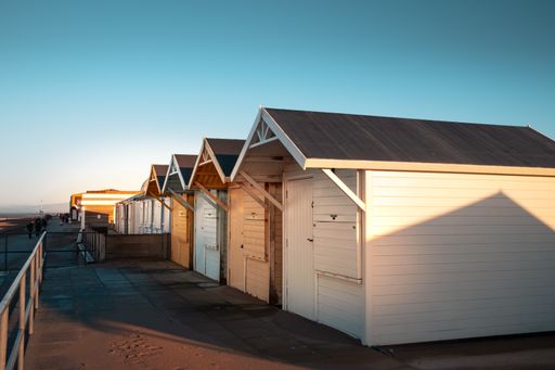 row of wooden beach huts brightly painted in pastel colors at the seaside