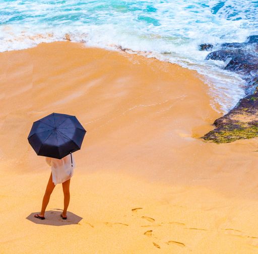 A high angle shot of a female with an umbrella on a sandy beach under sunlight in Bali