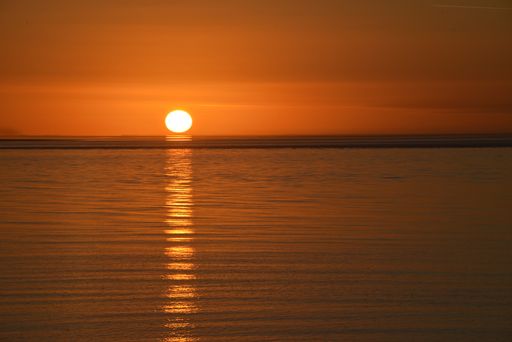 A breathtaking golden sunset shining onto the ocean waters with the sun reflecting a bright streak