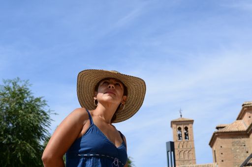 A Hispanic woman with a typical Colombian hat walking through the streets of Toledo, Spain