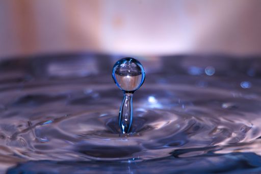 A macro shot of water droplet making ripples - great for wallpaper