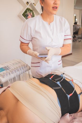 A vertical shot of a young Hispanic female getting an electric treatment at a spa