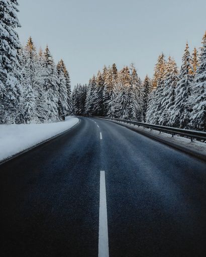 A Road In The Middle Of Snowy Forest