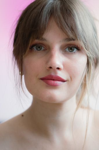 A beautiful Caucasian woman with a nose piercing looking at the camera
