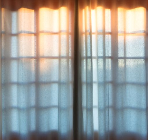White curtains covering window with sheets
