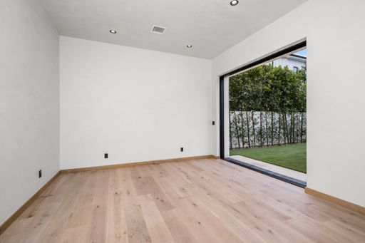 Empty room with hardwood floors and open sliding glass doors
