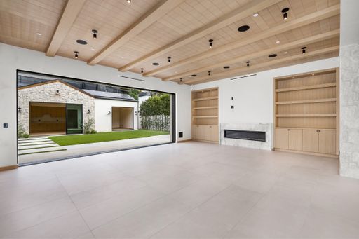 Spacious room with wooden beams, bright white walls, and ceiling