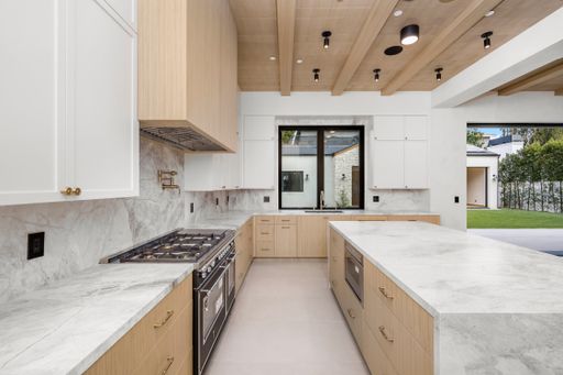 Marble countertop kitchen with backyard view through window