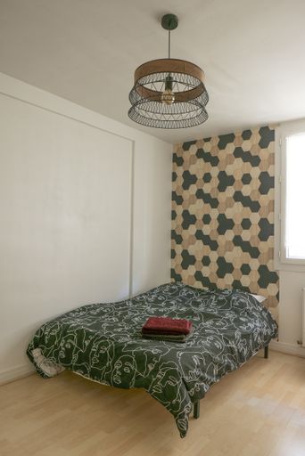 A vertical shot of a bedroom letting sunlight in from the window