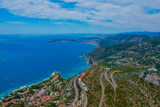 A picturesque city perched on a hillside, offering breathtaking views of the ocean and majestic mountains