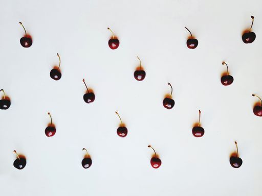 A top view of scattered fresh red cherries isolated on white background