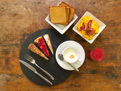 A top view of a tasty morning breakfast with cappuccino, toasts, and cakes