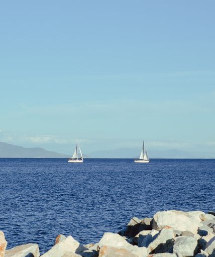 A vertical shot of sailboats on the calm sea in Mitilini, Lesbos, Greece