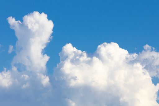 A scenic view of white fluffy clouds in the blue sky