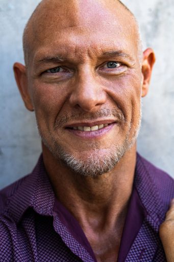 A portrait of a bald Caucasian man in his 50s.