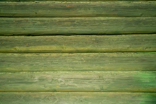 A closeup shot of an old green wooden surface with planks