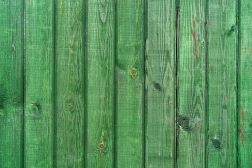 A closeup shot of an old green wooden surface with planks