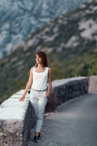 A young Caucasian female listening to music on the phone and enjoying the nature in Montenegro